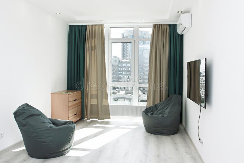  bedroom interior with two frameless armchairs, beech locker, with green curtains and a panoramic window with a view of the.  bedroom interior with two stock photography