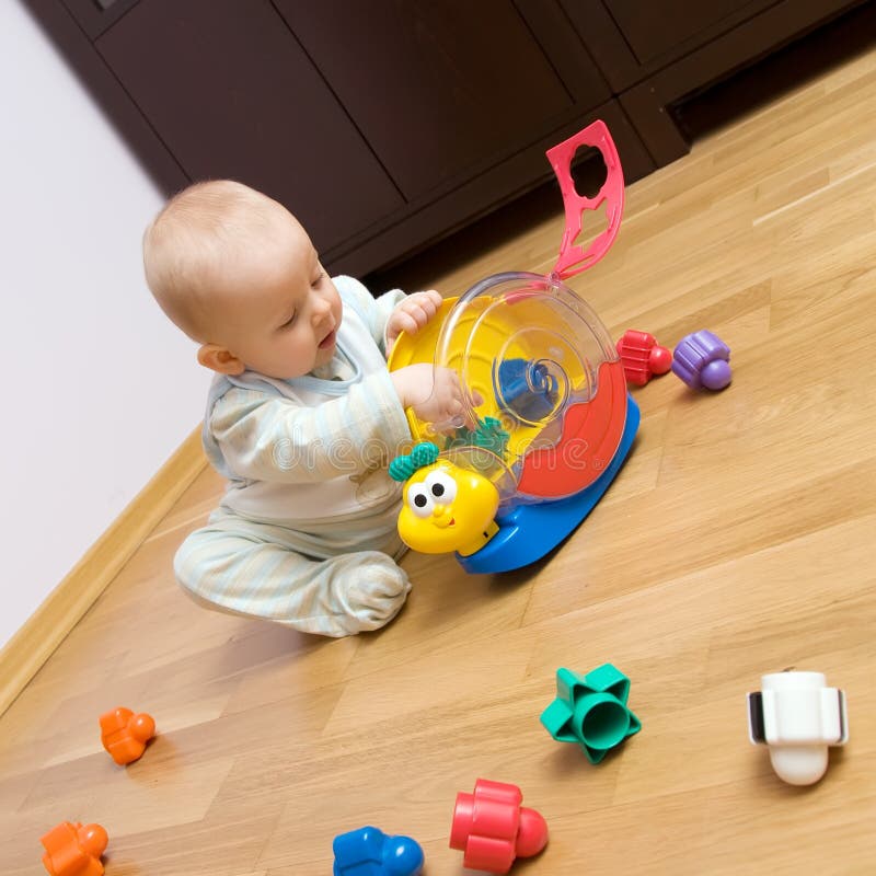 Baby playing with plastic toy royalty free stock image