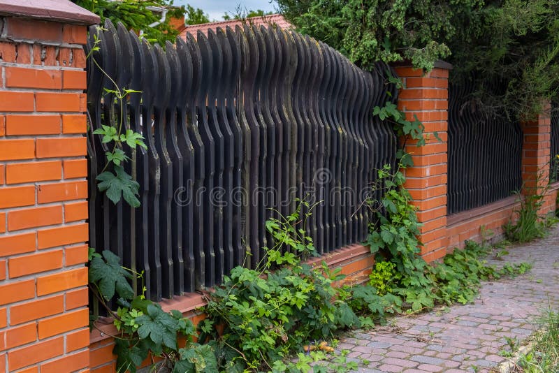Beautiful decorative modern wooden fence with brick columns stock image