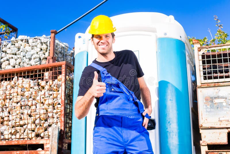 Builder using mobile toilet on site. Builder using mobile restroom or chemical toilet on construction or building site stock photo