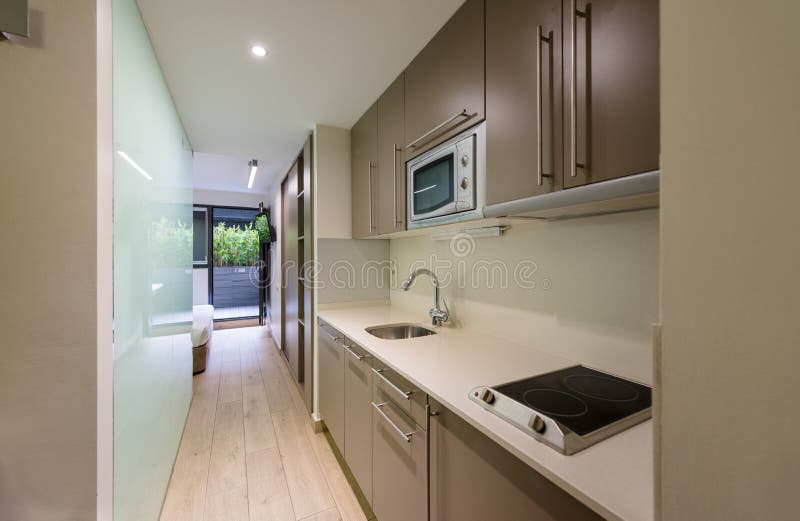 Kitchen interior in a small hotel apartment. Classic compact hotel apartment interior with integral kitchen, self-catering royalty free stock photos