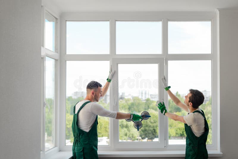 Construction workers install a window stock photography