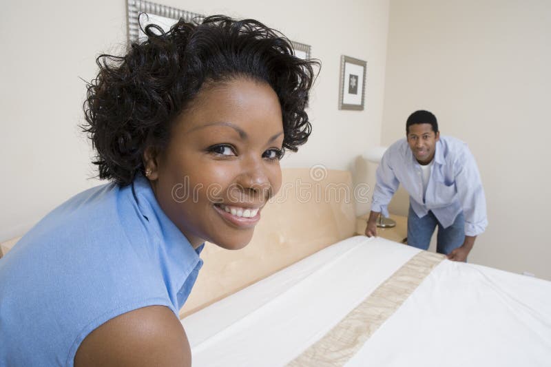 Couple Arranging Bed At Home royalty free stock images