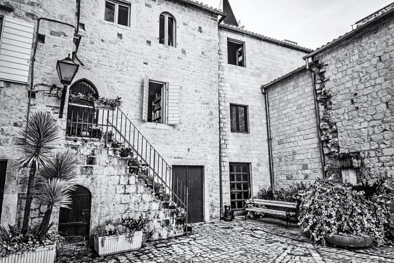 Courtyard of private house, Trogir, colorless. Courtyard of private house in old town Trogir, Croatia. Architectural theme. Travel destination. Black and white royalty free stock photo