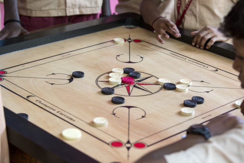 Documentary editorial image. Children playing carrom at the table. the concept of childhood and board games, brain development and royalty free stock image