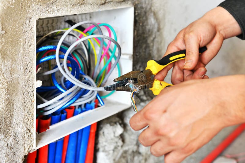Electrician installing a switch socket. The hands of an electrician installing a power switch socket royalty free stock photos