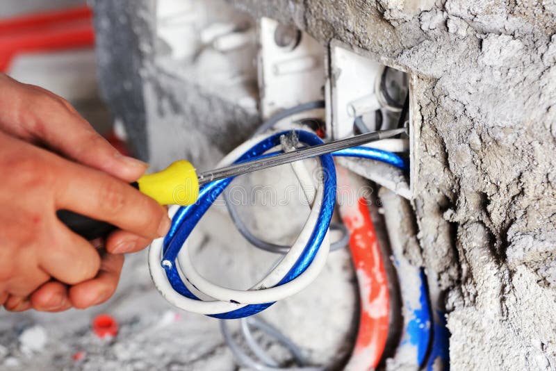 Electrician installing a switch socket. The hands of an electrician installing a power switch socket royalty free stock images