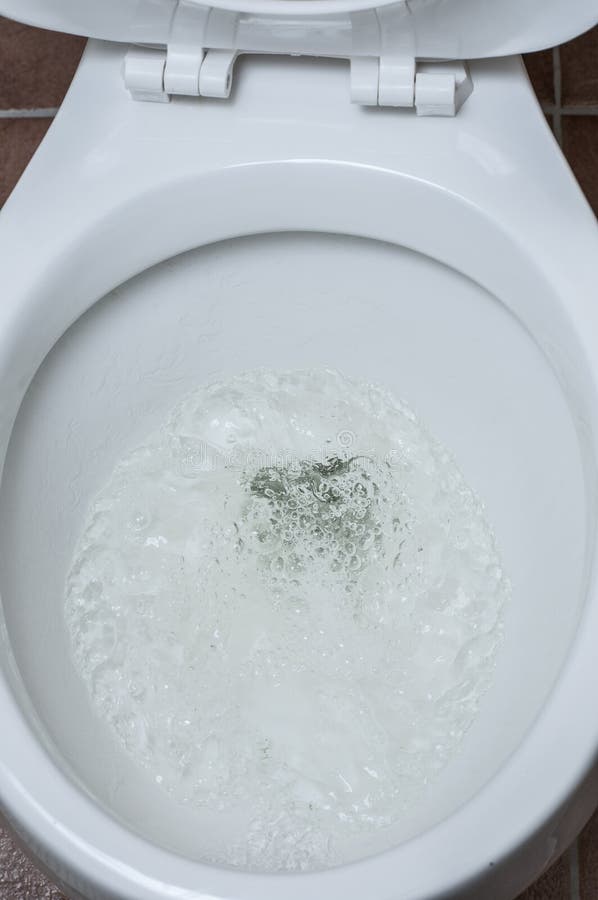 Flushing toilet. Water flushing down the toilet royalty free stock image