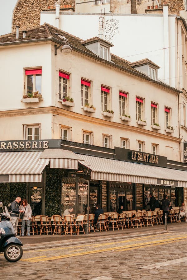 French cafe terrace. Paris, France - April 6, 2019: Charming traditional french cafe with tables on terrace in evening, landmark in Paris stock photography