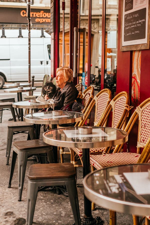 French cafe terrace. Paris, France - April 6, 2019: Charming traditional french cafe with tables on terrace, landmark in Paris royalty free stock image