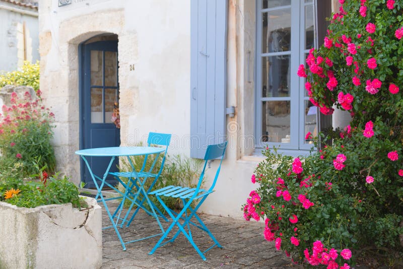 French terrace outdoor. Romantic French terrace with blue bistro set and pink roses royalty free stock photo