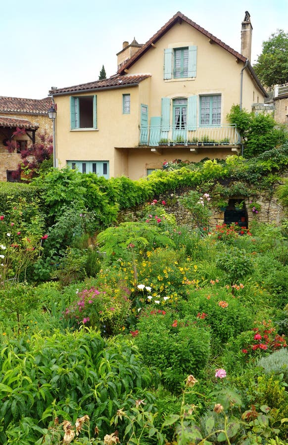 French town house with summer garden. A photograph showing an old stone house in a small mediaeval town in the south west of France, Europe, and the beautiful stock images