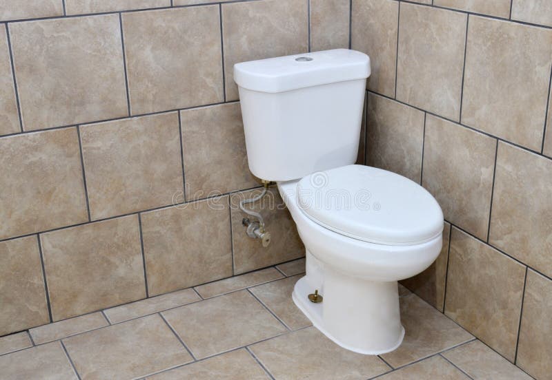 Installation of a new toilet. A new toilet installation done during a home bathroom basement renovation. A white toilet sits on a marble patterned floor royalty free stock images