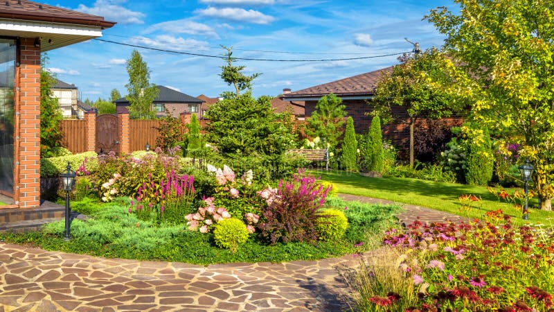 Landscape design at residential house. Beautiful landscaping in home garden. Moscow Region - Aug 24, 2019: Landscape design at residential house. Beautiful stock image