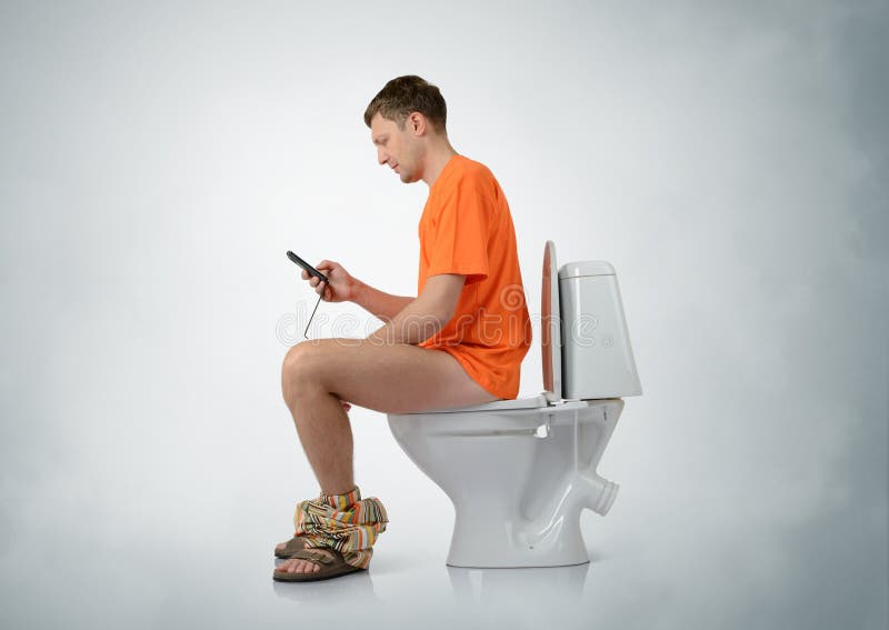 Man with smartphone sitting on the toilet. On background royalty free stock photos