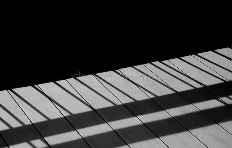 Metal fence with shadows on the wood floor. stock photo