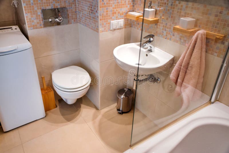 Modern simple interior in light apartments. Bathroom interior with glass door shower and mirror. Modern simple interior in light apartments. Bathroom interior stock photography