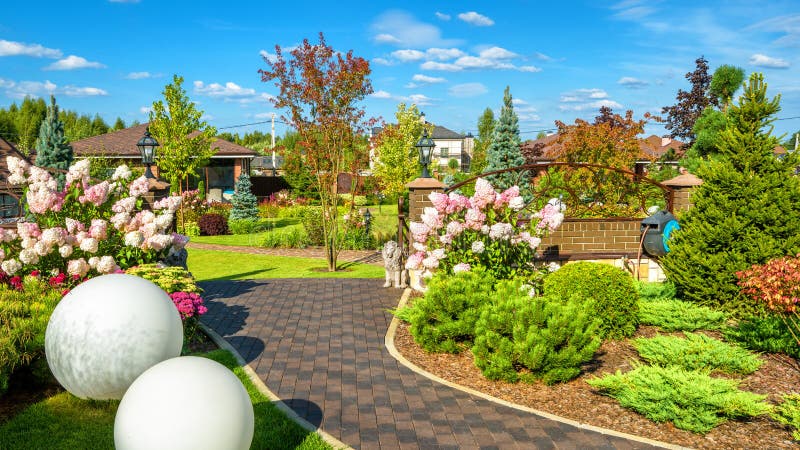 Landscape design at residential house. Beautiful landscaping in home garden. Panoramic view of nice landscaped garden in backyard. Moscow Region - Aug 24, 2019 royalty free stock photography