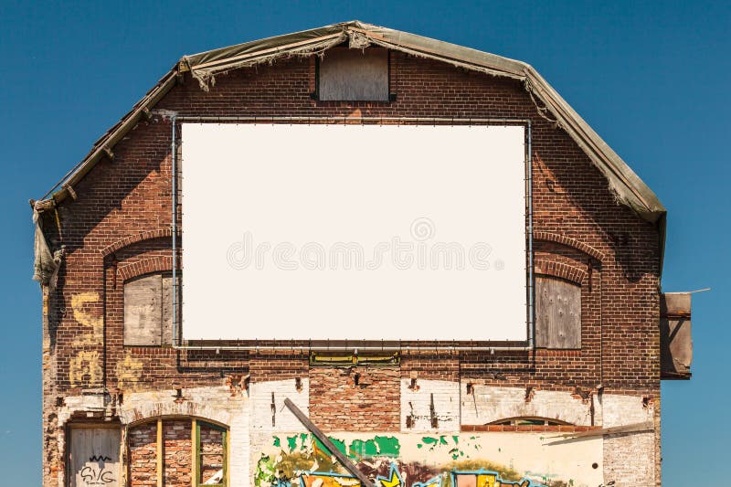 Old warehouse with an empty blank white canvas billboard stock image