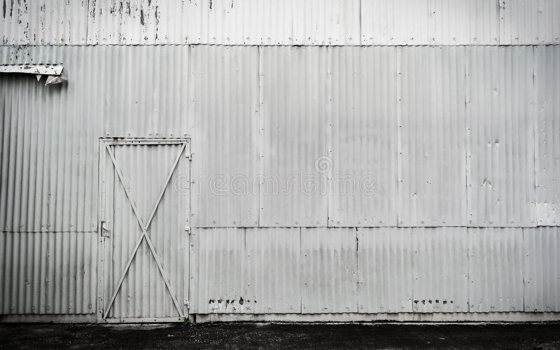 Old Zinc white dirty warehouse wall and small door background royalty free stock photography