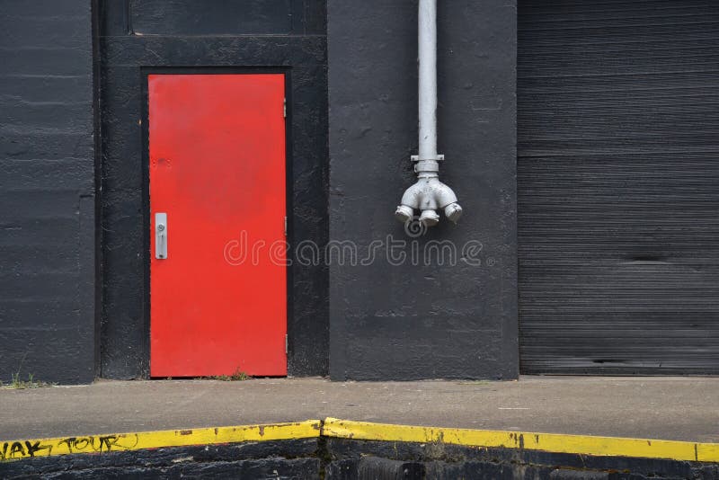 Orange Door, White Pipe, and Black Warehouse Wall, Portland, Oregon stock photography