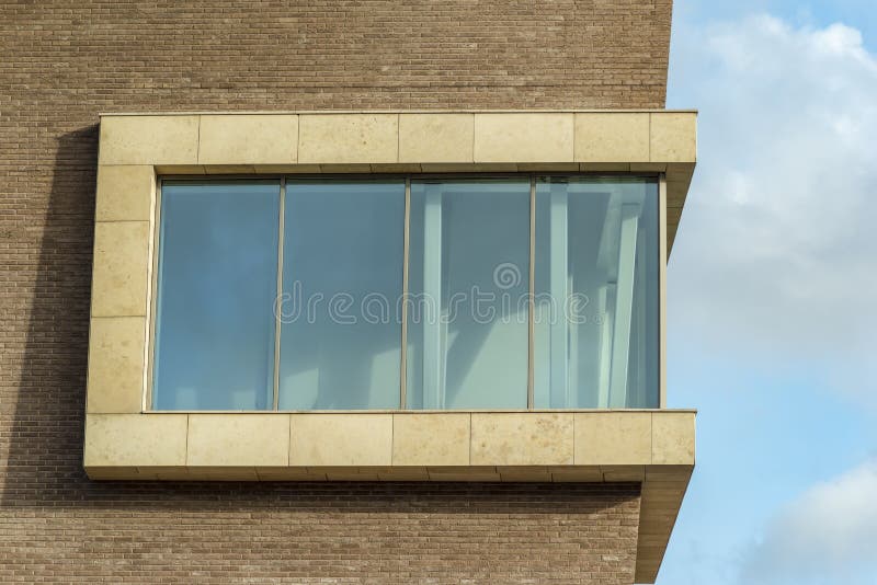 Panoramic window of a modern building. Panoramic window of a modern brick building against the blue sky royalty free stock photo