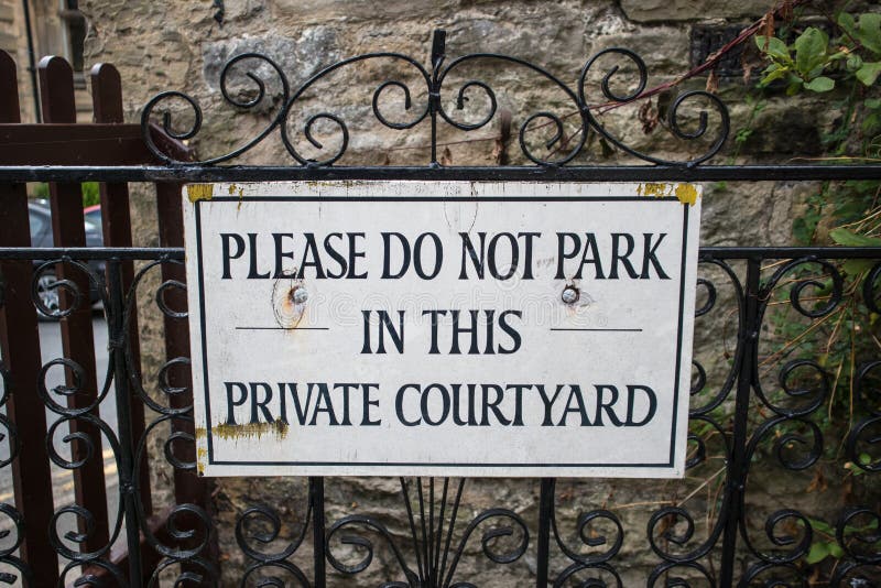 Please do not park in this private courtyard information sign. On ornate ironwork gate. No parking royalty free stock photography