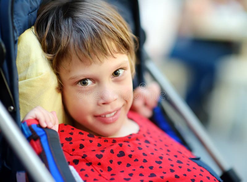Portrait of a cute little disabled girl in a wheelchair. Child cerebral palsy. Inclusion stock photography