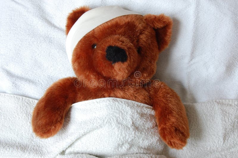 Sick teddy with injury in bed stock images