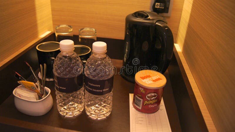 SINGAPORE - APR 2nd 2015: mini-bar corner in luxury hotel room with kettle, glasses, wine opener and chips royalty free stock image