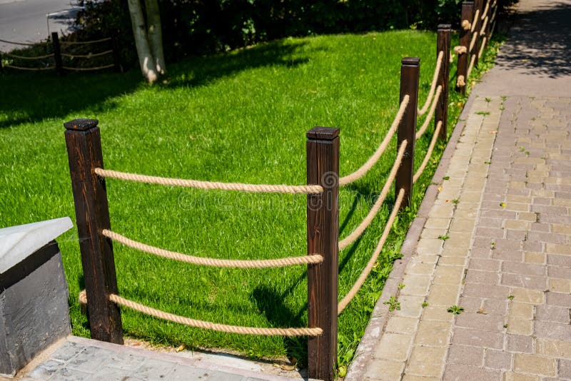 A small decorative fence . fence made from wooden poles and ropes stock photos