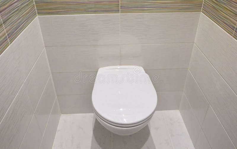 Toilet design with built-in toilet. Built-in toilet is made as an installation, all the elements, except for the toilet are hidden. Behind the tiles in the wall royalty free stock photos