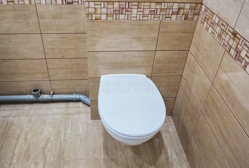 Toilet design with built-in toilet. Built-in toilet is made as an installation, all the elements, except for the toilet are hidden. Behind the tiles in the wall stock photo