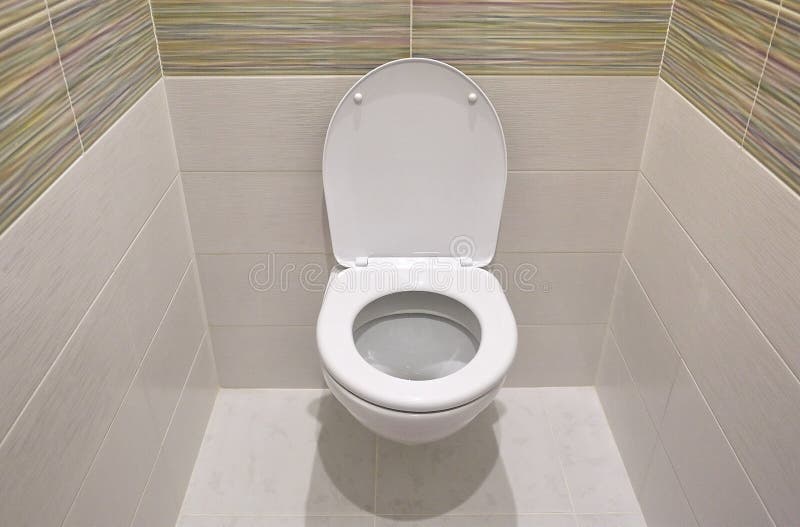 Toilet design with built-in toilet. Built-in toilet is made as an installation, all the elements, except for the toilet are hidden. Behind the tiles in the wall royalty free stock images
