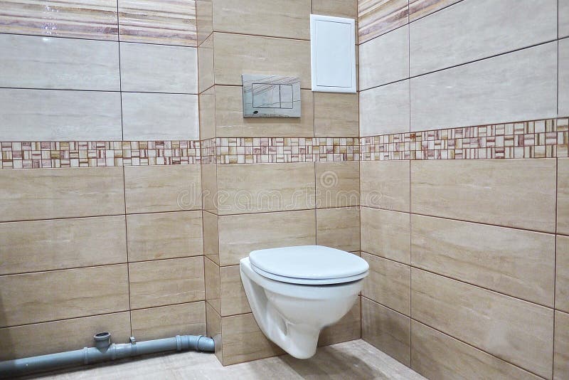 Toilet design with built-in toilet. Built-in toilet is made as an installation, all the elements, except for the toilet are hidden. Behind the tiles in the wall royalty free stock photo