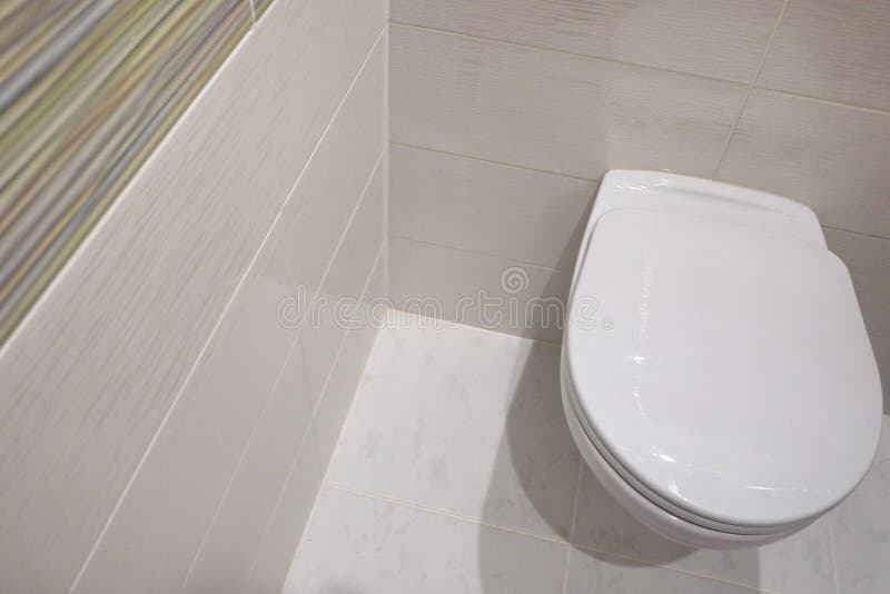 Toilet design with built-in toilet. Built-in toilet is made as an installation, all the elements, except for the toilet are hidden. Behind the tiles in the wall royalty free stock image