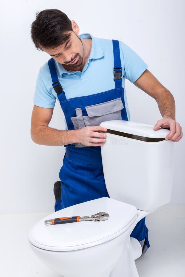 Toilet. Plumber is repairing a flush toilet, on white background royalty free stock photography