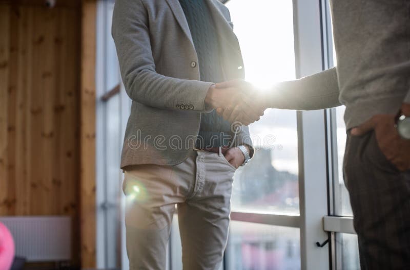 Two Business Man Shake Hand Agreement Coworking Center Business Team Coworkers Stand In Front Big Panoramic Window. Two Business Man Shake Hand Agreement royalty free stock images