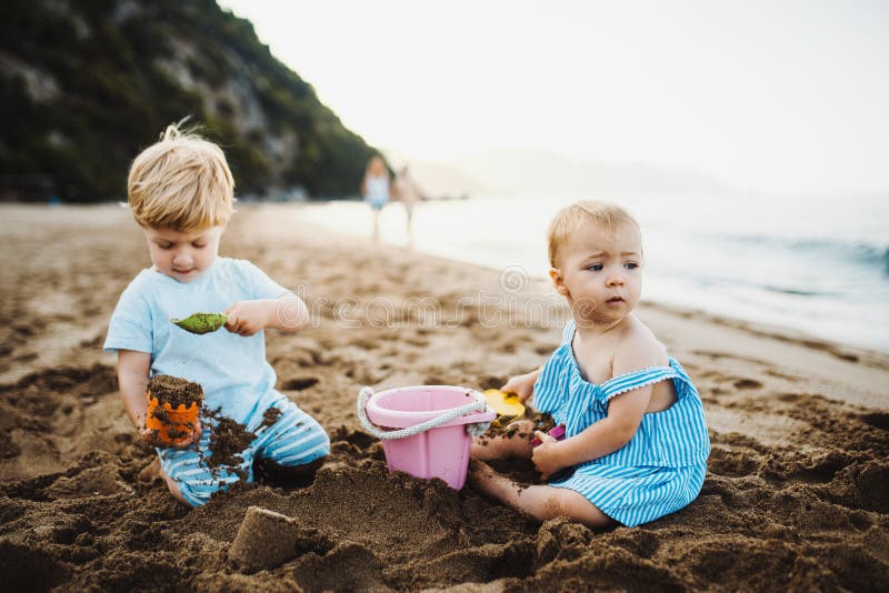 Two toddler children playing on sand beach on summer holiday. royalty free stock photo
