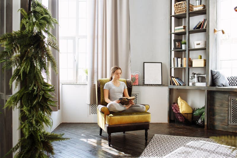 Woman reading book at home in the living room royalty free stock photography
