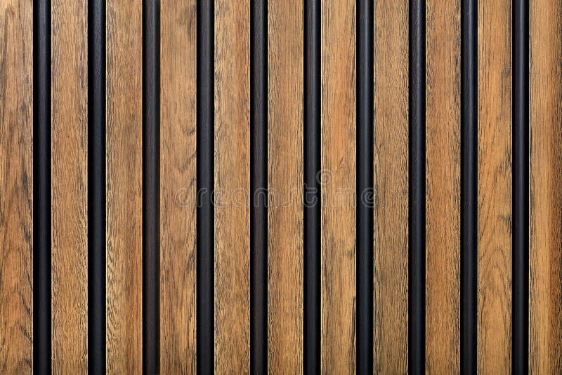 A fence made of vertical wooden decorative strips located parallel to each other stock image