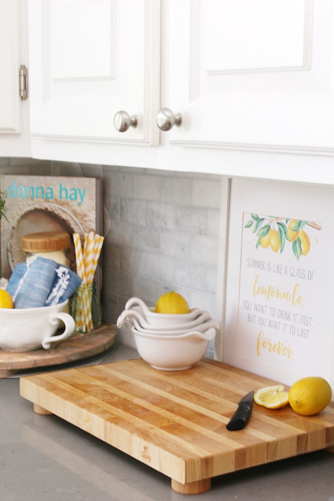Free lemonade printable displayed in a picture frame in a white kitchen.